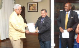 Minister of Agriculture Noel Holder (left) receiving the draft legislation from Minister of Indigenous Peoples’ Affairs Sydney Allicock (centre) with attorney Nigel Hughes (right)