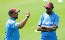IN BETTER TIMES: West Indies coach Phil Simmons (left) chats with Sir Curtly Ambrose during a training session.