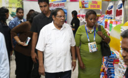 Prime Minister Moses Nagamootoo (centre) being taken on a tour of GuyExpo by Dawn Holder (right) 