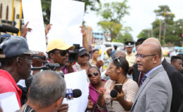 Opposition Leader Bharrat Jagdeo (right) speaking to protesting taxi drivers outside of Parliament yesterday. The drivers were protesting their removal from Stabroek Market Square.