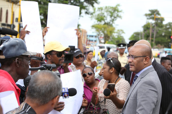 Opposition Leader Bharrat Jagdeo (right) speaking to protesting taxi drivers outside of Parliament yesterday. The drivers were protesting their removal from Stabroek Market Square.