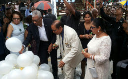 President David Granger and Prime Minister Moses Nagamootoo along with their spouses writing their personal commitments to the promotion of social cohesion on white helium filled balloons, which were later released up into the sky. (OPM Photo)