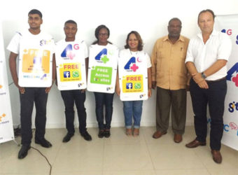 GTT Chief Commercial Officer Gert Post (right) and Ministry of Public Telecommunications Permanent Secretary, Derrick Cummings (second from right) with GTT employees advertising the new features. 