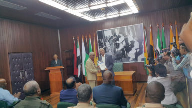 President David Granger (right in background) receiving the Commission of Inquiry’s Report into the Georgetown Prison unrest from Chairman of the Commission, Justice James Patterson. (Ministry of the Presidency photo) 