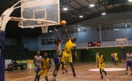 Nigel Bowen of Plaisance Secondary scores a layup while being challenged by a St. Stanislaus College player during their matchup in the U19 section of the National Schools Basketball Festival Georgetown and East Coast Regionals at the Cliff Anderson Sports Hall recently.