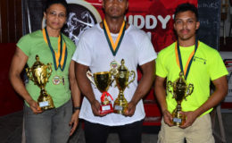 Winner’s Row! Nadina Taharally, Carlos Peterson and Romario Gonsalves pose with their spoils following the Claude Charles Intermediate and Master’s Championship yesterday at the Critchlow Labour College. (Orlando Charles photo)