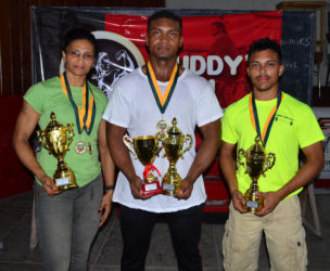 Winner’s Row! Nadina Taharally, Carlos Peterson and Romario Gonsalves pose with their spoils following the Claude Charles Intermediate and Master’s Championship yesterday at the Critchlow Labour College. (Orlando Charles photo)
