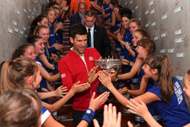 French Open champion Novak Djokovic celebrates with the ball girls. (Reuters photo)