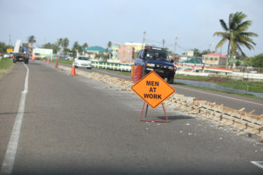 Another sign and cones in the background lining the construction in the middle of the road.  