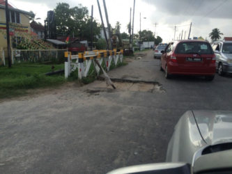 A crater at Plaisance with a pole stuck in the middle to alert drivers. 