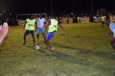 Akeem Saul (right) of Holmes Street Tiger Bay in the process of completing a pass to team mate Jamal Blackman (left) while Dennis Edwards (centre) of Sparta Boss pursues during their matchup in the Ministry of Health/Petra Organization Soft Shoe Championship at the Parade ground