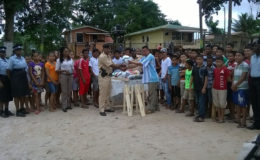 Commander of ‘F’ Division, division, Senior Superintendent Ravindradat Budhram (front, left) handing over the donation to a member of the Mabaruma Police Renaissance Youth Group. Also in photo are other ranks of the division and members of the youth group.