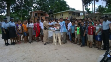 Commander of ‘F’ Division, division, Senior Superintendent Ravindradat Budhram (front, left) handing over the donation to a member of the Mabaruma Police Renaissance Youth Group. Also in photo are other ranks of the division and members of the youth group.