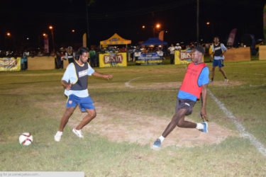 Darren Benjamin (right) of Broad Street completing a pass while being challenged by West Front Road’s Nathaniel Nagaloo during their matchup in the Ministry of Heath/Petra Organization soft shoe championships at the Santos Training Area.