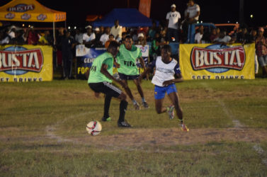Albouystown’s Lennox Cort (right/white) evading the challenge of Dennis Edwards of Tucville (left/green) in their high scoring drawn encounter at the Santos Training Area in the in the Ministry of Heath/Petra Organization soft shoe championships. 