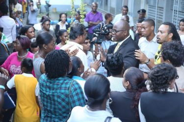 Chief Education Officer Olato Sam (right of centre with glasses) was bombarded with questions from irate parents during the meeting held yesterday to discuss the temporary closure of the Brickdam Secondary School.  (Keno George photo) 