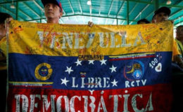 Opposition supporters hold a Venezuelan flag that reads ‘Venezuela free and democratic’ during a peaceful rally to demand a referendum to remove President Nicolas Maduro in Caracas, Venezuela June 12, 2016. Reuters/Ivan Alvarado
