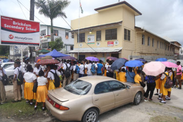 Students and their parents gathered in front of the Brickdam Secondary School to collect relocation letters yesterday morning. (Photo by Keno George) 