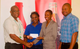 Former Olympian Aliann Pompey receives the sponsorship cheque from Brand Manager Clive Pellew while meet official Mayfield Taylor-Trim and Banks DIH’s Kester Van-Nooten look on.