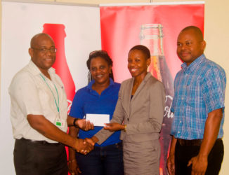 Former Olympian Aliann Pompey receives the sponsorship cheque from Brand Manager Clive Pellew while meet official Mayfield Taylor-Trim and Banks DIH’s Kester Van-Nooten look on.  