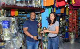 Petra Organization Co-Director Troy Mendonca collecting the trophies from Trophy Stall representative Devi Sunich yesterday.