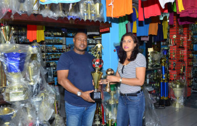 Petra Organization Co-Director Troy Mendonca collecting the trophies from Trophy Stall representative Devi Sunich yesterday.