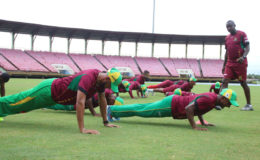 Strength and conditioning trainer Clinton Jeremiah looks on as members of the Guyana Amazon Warriors team engage in some planking as part of their first day of training camp yesterday at Providence.
