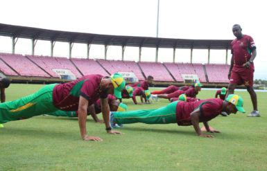 Strength and conditioning trainer Clinton Jeremiah looks on as members of the Guyana Amazon Warriors team engage in some planking as part of their first day of training camp yesterday at Providence.  