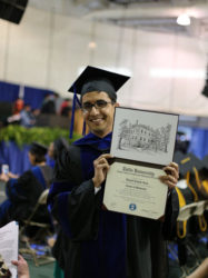 Daniel Ram holds up his Phd in Immunology  