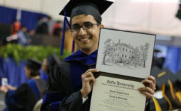 Daniel Ram holds up his Phd in Immunology