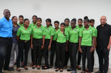 Members of the Guyana U-19 girls team pose for a photograph with Chief Executive Officer of Top Brandz Distributors, Wayne James (right) and Technical Development Officer of the Guyana Cricket Board, Colin Stuart (left) manager, Devika Gobin (2nd left). Captain Plaffianna Millington is first from left front row). 