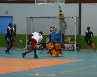 Old Fort’s Aderemi Simon unleashing a powerful shot which was denied by GCC’s Stephen Xavier (behind the goalkeeper) during their matchup at the National Gymnasium.