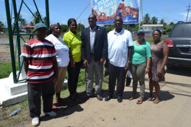 Minister of State,  Joseph Harmon (centre) with Chairman of the Lancaster/Hogstye NDC Forbes Moore (third from right) along with other members of the community during one of his visits to East Berbice-Corentyne.  (Ministry of the Presidency photo) 