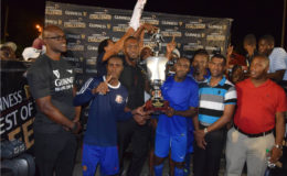 Dynasty sealed- Captain of Sparta Boss outfit Devon Millington collecting the championship trophy from Sports Director Christopher Jones while members of the team and Banks DIH Limited look on.