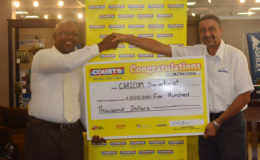 Managing Director of Courts, Clyde de Haas, handing over a cheque worth $500,000 to Race and Programme Manager for Crime and Security at CARICOM, Sherwin Toyne-Stephenson.