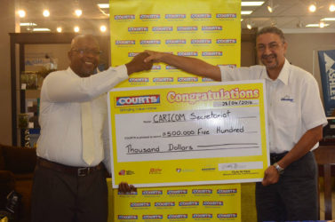 Managing Director of Courts, Clyde de Haas, handing over a cheque worth $500,000 to Race and Programme Manager for Crime and Security at CARICOM, Sherwin Toyne-Stephenson. 