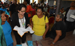 Two participants in the Self Reliance and Success in Business Workshop in Mahdia give First Lady,  Sandra Granger (centre) a closer look at their hand-embroidered tea towels.  (Ministry of the Presidency photo)