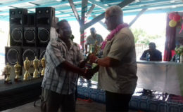  A fisherman (left)  receives his award from Minister of Agriculture Noel Holder yesterday
