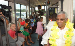 Checking out the school bus: President David Granger (right) seated in the David G No. 10 with children of Coomacka. (Ministry of the Presidency photo)