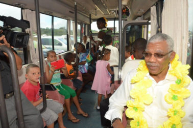 Checking out the school bus: President David Granger (right) seated in the David G No. 10 with children of Coomacka. (Ministry of the Presidency photo)