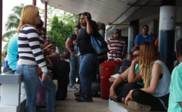 Venezuelan nationals wait to board a boat at Cedros before checking in with Immigration officials last Wednesday.