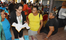Two participants in the Self Reliance and Success in Business Workshop in Mahdia give First Lady,  Sandra Granger (centre) a closer look at their hand-embroidered tea towels.  (Ministry of the Presidency photo)