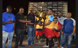 BV-B captain Erin Fraser collecting the championship trophy from Guinness Brand Manager Lee Baptiste after defeating Haslington North in the final while other members of the team and Petra Organization Co-Director Troy Mendonca (right) look on.