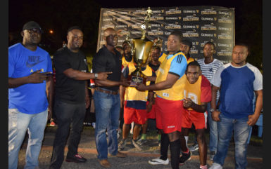 BV-B captain Erin Fraser collecting the championship trophy from Guinness Brand Manager Lee Baptiste after defeating Haslington North in the final while other members of the team and Petra Organization Co-Director Troy Mendonca (right) look on.  