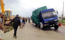 This truck, laden with rice, fell into a pothole at Uitvlugt, West Coast Demerara this morning, where road construction is in progress. It resulted in a disruption of traffic and senior officials of the project visited the scene to bring the situation under control. An excavator also had to be summoned to assist in getting the truck out.
