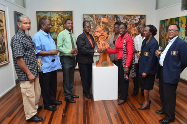 GPSCCUL hands over the piece to Minister Nicolette Henry, third from right. Winslow Craig is at left. (GINA photo)