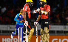 Dwayne Bravo (left) and Hashim Amla discuss strategy during their record fifth wicket stand against Barbados Trident on Friday night. (Photo courtesy CPL)
