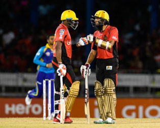 Dwayne Bravo (left) and Hashim Amla discuss strategy during their record fifth wicket stand against Barbados Trident on Friday night. (Photo courtesy CPL)  