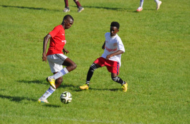 Action between Soesdyke Secondary (white) and Covent Garden in the Digicel Schools Football Championship at the Leonora Sports Facility 