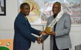 Minister of State Joseph Harmon (right) receiving a token of appreciation from President of the DCC, Alfred Mentore.  (Ministry of the Presidency photo)
